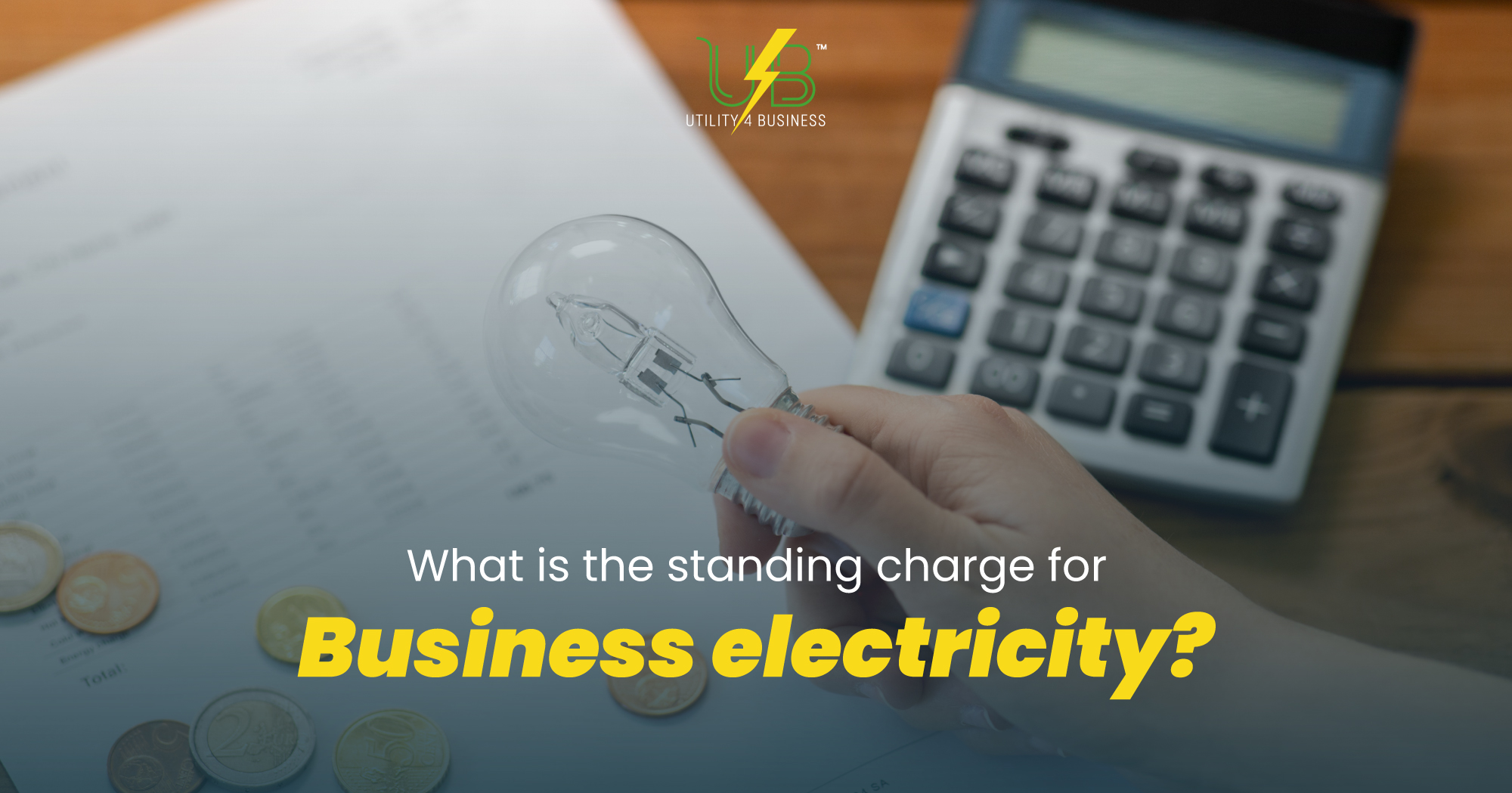 Hand holding lightbulb near coins and calculator, showing UK business electricity standing charges — Utility4Business.